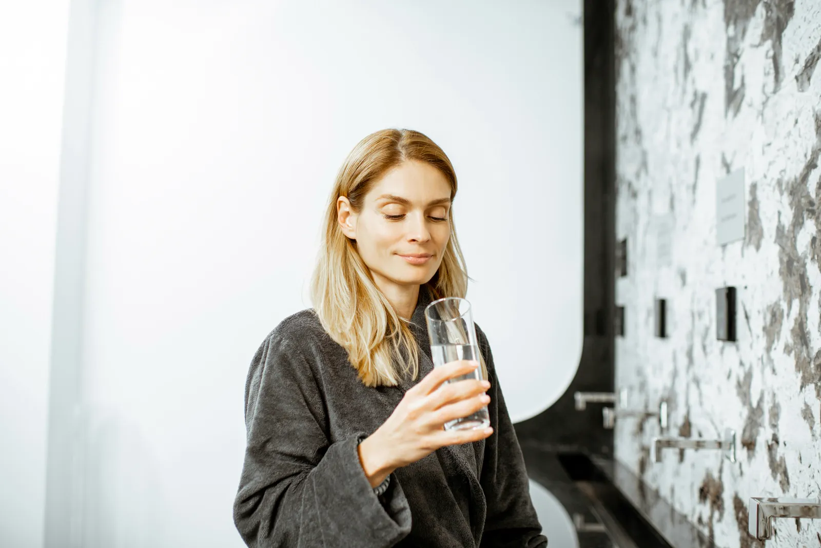 Woman calmly holding a glass of water — understanding your own exposure and health history matters more than a headline